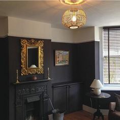 a living room filled with furniture and a fire place in front of a mirror on the wall