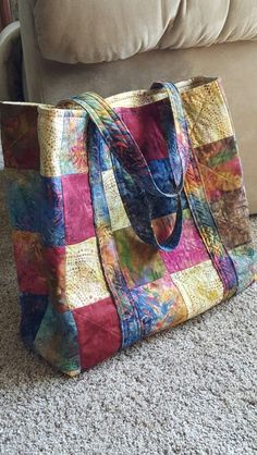 a multicolored bag sitting on the floor next to a couch