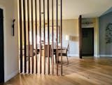 a room divider made out of wooden slats in the middle of a wood floor