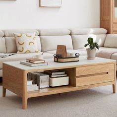 a living room with a couch, coffee table and books on the shelf next to it