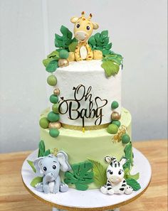 a baby shower cake with an elephant and giraffe on top