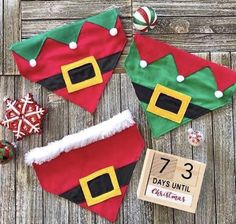 three christmas decorations are laid out on a wooden surface, including santa's hats and candy canes