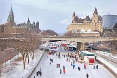 many people are skating on the ice in front of a large building with spires