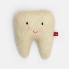 a tooth shaped pillow with a smile on it