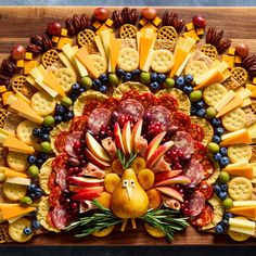 a turkey made out of crackers, grapes, apples, cheese and meats