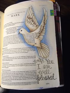 an open book with a drawing of a dove on the page and words written in it