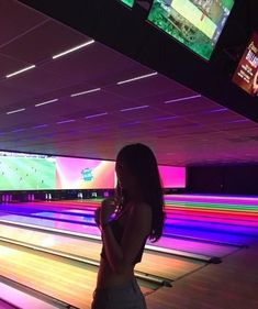 a woman standing in front of bowling lanes