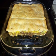 a casserole dish sitting on top of a stove in a glass baking pan