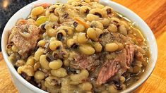 a white bowl filled with beans and meat