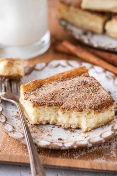 a piece of cake sitting on top of a plate next to a glass of milk