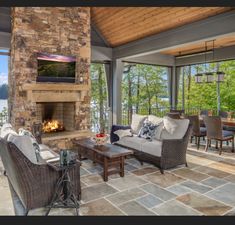 a living room filled with furniture and a fire place in front of a stone fireplace