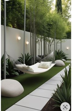 a white hammock sitting on top of a grass covered field next to trees