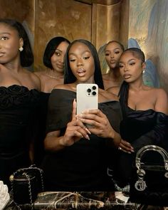 a group of women standing next to each other in front of a mirror taking a selfie