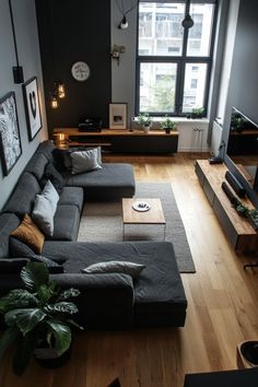 a living room filled with lots of furniture and a flat screen tv mounted to the wall