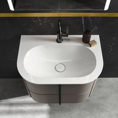 a white sink sitting on top of a counter next to a black wall mounted mirror