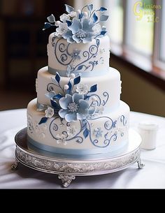 a three tiered wedding cake with blue flowers