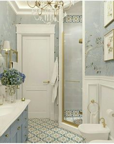 a white bathroom with blue and gold decor