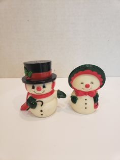 two ceramic snowmen wearing hats and scarves