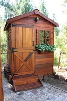 a small wooden shed sitting on top of a brick patio