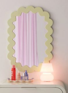 a white dresser topped with a mirror next to a lamp