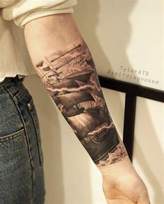 a person with a tattoo on their arm and the image of ships in the ocean