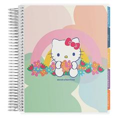 a spiral notebook with hello kitty on the front and flowers in the middle, sitting on top of an egg