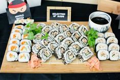 sushi platter with chopsticks and sauce on the side, along with other food items