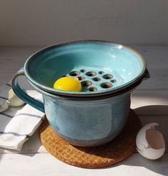 an egg is in a blue bowl on a place mat