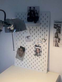 a white desk topped with pictures and a lamp