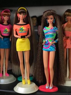 three barbie dolls are standing next to each other with long brown hair and colorful outfits