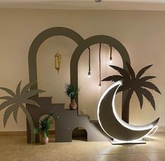 an artistic display with palm trees and moon in the center, surrounded by other decorative objects