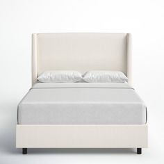 a bed with white linens and pillows on it's headboard is shown