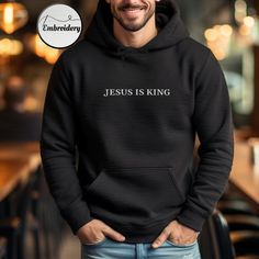 Embroidered Jesus Is King Hoodie  High-quality embroidery - Made from premium materials, this pullover hoodie ensures both warmth and comfort. The classic design makes it a versatile addition to your Christian wardrobe. Christian Hoodie Features: * 50% pre-shrunk cotton, 50% polyester * Double-lined hood with matching drawcord * Front pouch pocket * High quality embroidery with Bible verse * Available in a range of sizes and colors, it's suitable for both men and women. Christian Clothing: I love adorning shirts with scripture, as it helps spread the message of the Good News of Christ. Each Bible verse woven into fabric has the power to convey profound truths, speaking to anyone who encounters them. This hooded sweatshirt is made especially for you as soon as you place an order, which is w Hooded Winter Sweatshirt With Embroidered Graphics, Cotton Hoodie With Embroidered Text And Long Sleeves, Winter Hooded Sweatshirt With Embroidered Graphics, Long Sleeve Cotton Hoodie With Embroidered Text, Cotton Long Sleeve Hoodie With Embroidered Text, Long Sleeve Hoodie With Letter Embroidery For Streetwear, Streetwear Long Sleeve Hoodie With Letter Embroidery, Cotton Hooded Sweatshirt With Embroidered Text, Embroidered Fleece Hooded Sweatshirt