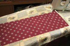 an ironing board on top of a table next to a sewing machine and other items