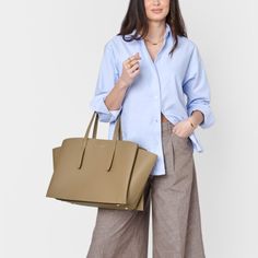 Designed to enhance your daily routine, our Tabi Large Tote Bag in Taupe features a spacious interior that accommodates most laptop models, making it perfect for both casual and professional occasions. It also includes a removable zip pouch suitable for devices up to 13 inches, along with a D-ring for personalizing with Clip-On Accessories. Pebble vegan leather design with soft suedette lining Features shoulder straps, 3 internal compartments, removable pocket pouch, and internal D-ring for Clip Rectangular Laptop Bag With Removable Pouch For Work, Versatile Briefcase With Laptop Sleeve, Satchel Style, Casual Office Satchel With Top Carry Handle, Casual Large Capacity Laptop Bag For Office, Versatile Satchel Laptop Bag With Removable Pouch, Versatile Laptop Bag With Sleeve, Versatile Briefcase Tote For Work, Versatile Laptop Satchel Bag With Removable Pouch, Versatile Briefcase Tote For Professional Use