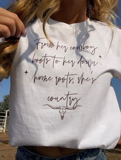 Brand new item!!  The perfect white t-shirt. A quote from a personal favorite song "from her cowboy boots to her down home roots, she's country" and a delicate outlines cow skull.  Made from 50% cotton and 50% polyester! Free shipping and limited quantity! If you would like this design on a different colored t-shirt message us and we are happy to customize it for you! White Short Sleeve Tops For Country Events, Western White T-shirt For Country Events, Western Style White T-shirt For Country Events, White Graphic Tee For Western-themed Events, Country Style White Graphic T-shirt, White Cotton Top For Country Events, White Cotton Tops For Country Events, Casual White T-shirt For Western-themed Events, Country Style White Cotton T-shirt