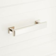 a close up of a bathroom door handle on a white wall with horizontal lines in the background