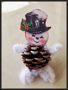 a small white teddy bear wearing a top hat and holding a pine cone with its paws