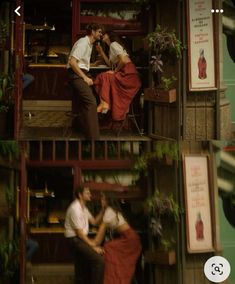 two people are kissing in front of a store with flowers on the window sill