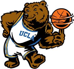 a brown bear holding a basketball in his right hand and wearing a white shirt with the word ucla on it