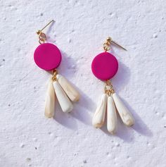 These statement earrings are equal parts colourful and elegant! Handmade from polymer clay, the vibrant hot pink adds a fun pop of colour, which is offset perfectly by the three pearl white hand-rolled teardrop beads. These are a chic pair of earrings which are perfect for cartwheeling into the sunny weather with! Material: polymer clay, gold-plated ball posts Approximate dimensions: Drop - 6.8cm, Width - 2cm Weight: 6 grams/earring - clay is a super lightweight material! Packaging: Your earring Magenta Earrings, Earring Clay, Pink Statement Earrings, Dark Blue Earrings, Aesthetic Earrings, Pink Heart Earrings, Small Dangle Earrings, Diy Earrings Polymer Clay, Quirky Jewelry