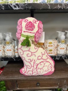 a pink dog keychain sitting on top of a wooden table next to other items