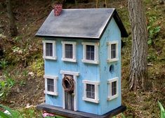 a blue birdhouse sitting on top of a tree stump