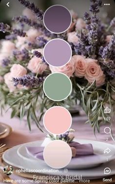 a vase filled with lots of pink flowers on top of a table next to plates