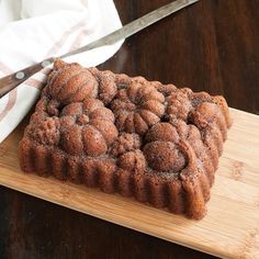 a cake sitting on top of a wooden cutting board with a knife next to it