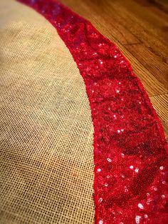 red sequins are on the side of a piece of burluck fabric