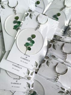 wedding favors and keychains with green leaves on them