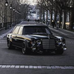 an old black car is parked on the street