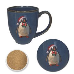 a penguin with a santa hat and bow on it's head is next to a coffee cup