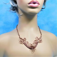 Non tarnish antique colored copper wire is hand woven, sculpted, and wrapped with copper beads, to form a light weight, one of a kind bib style necklace that is elegant enough for formal wear, and yet understated enough for casual every day wardrobe choices. The bib is suspended from individually wire wrapped beaded links, creating an elegantly detailed piece of artisan crafted jewelry that stands the test of time. The total length, including beaded link chain, measures 20 inches. Your one of a Handmade Rose Gold Copper Jewelry, Artistic Wire Wrapped Copper Jewelry, Artistic Handmade Copper Jewelry, Bohemian Adjustable Wire Necklaces, Hand Wrapped Bronze Copper Necklaces, Bohemian Bronze Jewelry With Copper Wire, Hand Forged Bohemian Rose Gold Jewelry, Artistic Copper Wire Wrapped Jewelry, Elegant Hand Wrapped Copper Necklaces